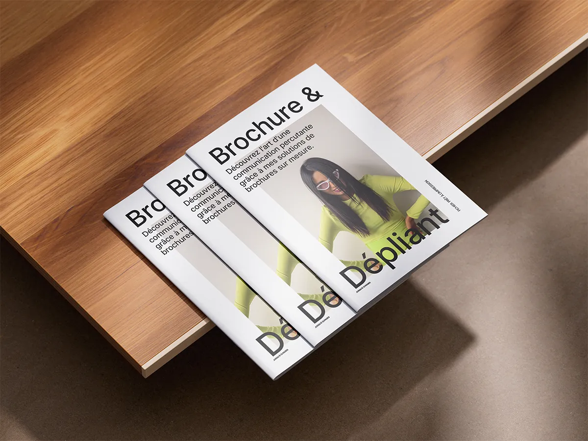 Brochures et dépliants empilés sur une table en bois : réalisations de Studio Macla